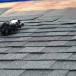 close up on nail gun on the roof shingle